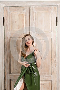 Young attractive girl with white curly hair in a green dress