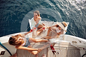 Young attractive girls enjoyng the wine on stern of a yacht