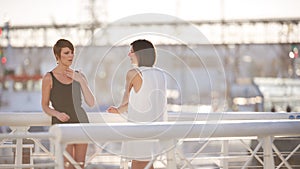 Young attractive girls standing outdoors on a bridge laughing together