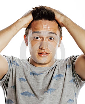 Young attractive handsome man holding hands on his head emotional wondering isolated on white