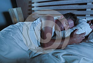 Young attractive and handsome tired man on his 30s or 40s in bed sleeping peacefully and relaxed at apartment bedroom resting comf