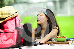 Young attractive and happy Asian Korean digital nomad working outdoors relaxed with laptop computer at tropical cafe in success on