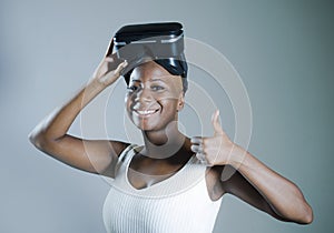 Young attractive and happy black afro american woman showing VR 3d vision goggles after enjoying amazing experience playing