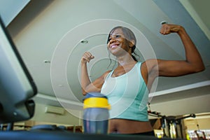 Young attractive and happy black afro American woman training at gym doing treadmill workout fitness machine posing playful