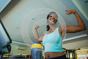 Young attractive and happy black afro American woman training at gym doing treadmill workout fitness machine posing playful