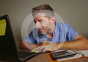 Young attractive and happy business man working with laptop computer at home office smiling satisfied and confident in successful