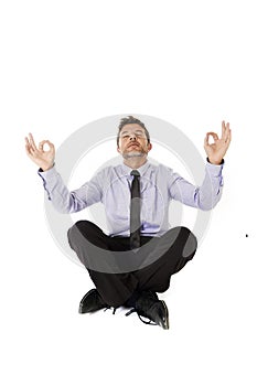 Young attractive happy businessman relaxing with hands in yoga position sitting on the floor