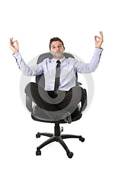 Young attractive happy businessman relaxing with hands in yoga position sitting on office chair
