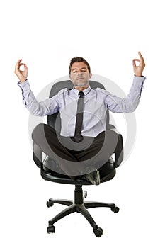 Young attractive happy businessman relaxing with hands in yoga position sitting on office chair