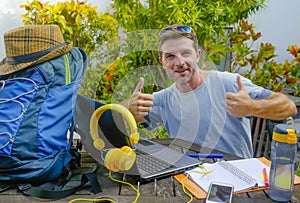Young attractive and happy digital nomad man working outdoors with laptop computer cheerful and confident running business remote
