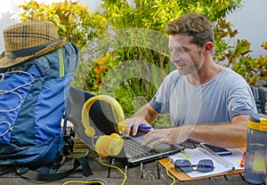 Young attractive and happy digital nomad man working outdoors with laptop computer cheerful and confident running business remote photo