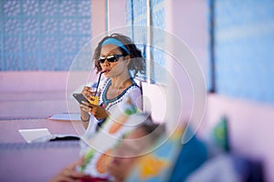 Young attractive and happy hipster Asian woman working with laptop computer and mobile phone at relaxing outdoors workplace enjoyi