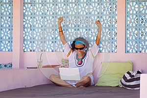 Young attractive and happy hipster Asian woman working with laptop computer at relaxing outdoors workplace enjoying success as int