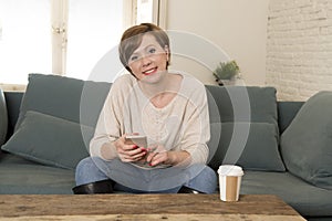 Young attractive and happy red hair woman sitting at home sofa c