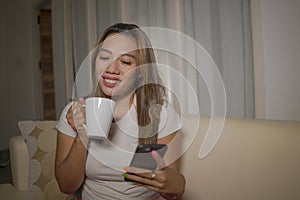 Young attractive happy and relaxed hispanic woman enjoying homey at living room sofa couch using internet social media or dating