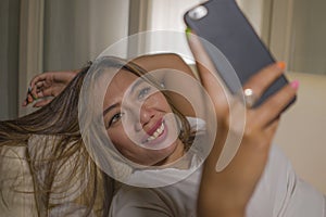 Young attractive happy and relaxed student Asian woman enjoying homey lying at living room sofa couch using internet social media