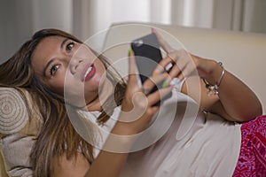 Young attractive happy and relaxed student girl enjoying homey at living room sofa couch using internet social media or dating app