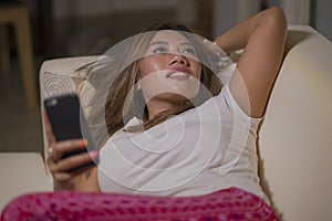 Young attractive happy and relaxed student girl enjoying homey at living room sofa couch using internet social media or dating app