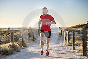 Young attractive and happy sport runner man with fit and strong healthy body training on off road track in Summer running workout