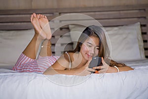 Young attractive and happy teenager woman lying relaxed and smiling cheerful in bed using internet social media or online dating