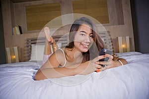 Young attractive and happy teenager woman lying relaxed and smiling cheerful in bed using internet social media or online dating