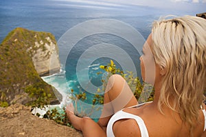 Young attractive and happy tourist woman looking the stunning view of beautiful sea cliff beach at viewpoint enjoying exotic