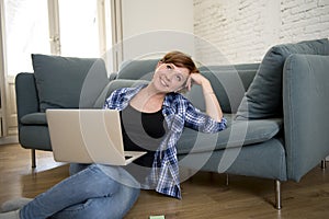 young attractive and happy woman at home sofa relaxed and dreamful using computer laptop shopping on line smiling excited