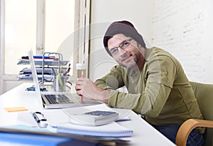 Young attractive hipster businessman working from his home office as freelancer self employed business model