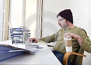 Young attractive hipster businessman working from his home office as freelancer self employed business model