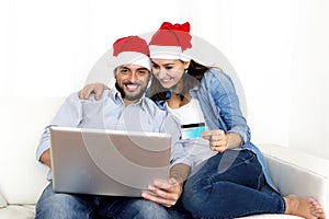 Young attractive Hispanic couple in love online Christmas shopping with computer