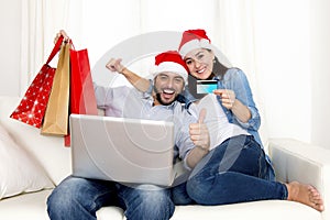 Young attractive Hispanic couple in love online Christmas shopping with computer