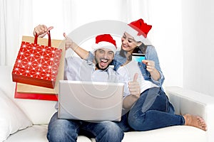 Young attractive Hispanic couple in love online Christmas shopping with computer