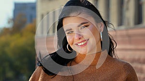 Young attractive hispanic girl student model looking at camera posing standing alone outdoors for close-up portrait