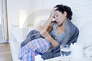 Young attractive hispanic woman lying sick at home couch in cold and flu in gripe disease symptom