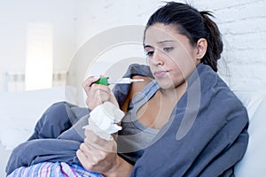 Young attractive hispanic woman lying sick at home couch in cold and flu in gripe disease symptom