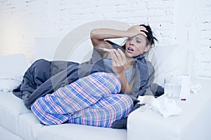 Young attractive hispanic woman lying sick at home couch in cold and flu in gripe disease symptom