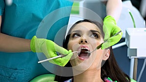 Young attractive lady at regular checkup in dentistry clinic, oral cavity health