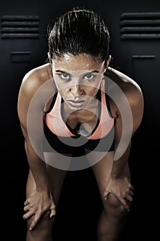 Young attractive latin sport woman posing in fierce and badass face expression with fit slim body