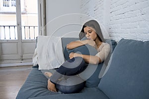 Young attractive latin woman lying at home couch worried suffering depression feeling sad and desperate