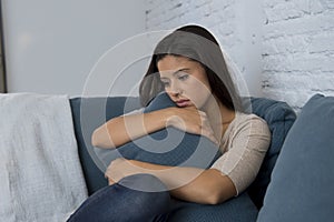 Young attractive latin woman lying at home couch worried suffering depression feeling sad and desperate