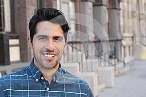 Young and attractive latino male smiling in the city