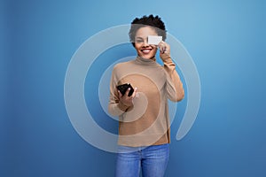 young attractive latino woman with black afro ponytail holding map and phone