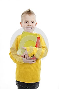 Young attractive little boy holding school books, looking excited about going back to school