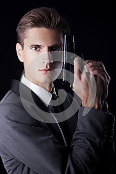 Young attractive macho in suit with gun