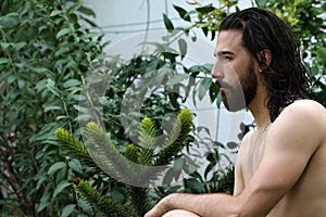 Young, attractive male model with long hair and beard posing in nature.