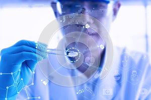 Young attractive male scientist holding a red transparent pill with futuristic scientific air interface