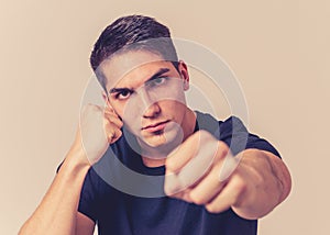 Young attractive man with an angry face in boxing stance ready to fight