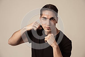 Young attractive man with an angry face in boxing stance ready to fight