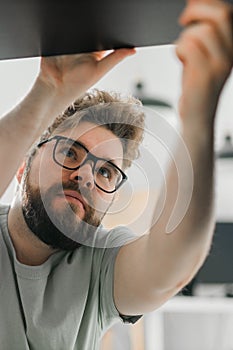 Young attractive man assembles furniture - handwerker and interior objects concept