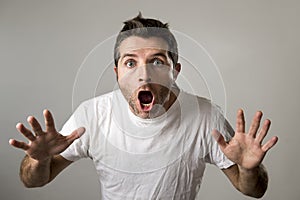 Young attractive man astonished amazed in shock surprise face expression and shock emotion photo